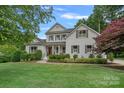 Traditional style house with manicured lawn, mature trees, and a welcoming front porch at 109 Walking Horse Trl, Davidson, NC 28036