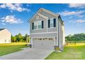 Well-maintained gray home with a two-car garage, manicured lawn, and classic architectural details at 112 Aspire Cir, Wingate, NC 28174