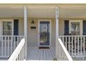 Inviting front porch with a rocking chair, black shutters, and a decorative door wreath at 113 Ervin St, Belmont, NC 28012