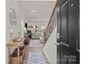 Welcoming foyer with hardwood floors, staircase, and view into the sunlit living room at 1207 Skyflower Way, Charlotte, NC 28214