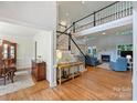 Spacious foyer with hardwood floors, featuring a staircase and offering views of the formal living room at 12644 Lahinch Ct, Charlotte, NC 28277