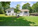 Well-maintained home exterior with mature tree, showcasing a tidy front lawn at 14821 Cumberland Dr, Charlotte, NC 28227