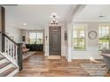 Bright foyer with hardwood floors, wainscoting, and staircase showcasing the home's interior at 15103 Keyes Meadow Way, Huntersville, NC 28078