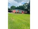 Spacious front lawn leads to this red brick home with covered entry at 1535 Jordan St, Lancaster, SC 29720