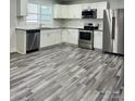 Modern kitchen features stainless steel appliances, white cabinets, and stylish flooring at 1535 Jordan St, Lancaster, SC 29720