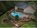 Aerial view of a backyard with a beautiful pool, patio, outdoor kitchen, and landscaped gardens at 1912 Dawnhurst Ln, York, SC 29745
