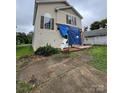 Damaged two-story home featuring a front porch, siding, and windows covered with a blue tarp at 2012 Ashley Rd, Charlotte, NC 28208