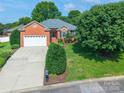 Aerial view of a red brick home that features an attached garage and a well-maintained lawn and landscaping at 2079 Audubon Dr, Rock Hill, SC 29732