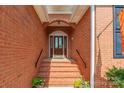 The brick house features an elegant front door with glass accents and classic design, framed by brick steps at 2079 Audubon Dr, Rock Hill, SC 29732