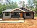 Inviting home with gray siding, covered porch, black railings and trim, and a walkway leading to the entrance at 2330 Neill Rd, Lancaster, SC 29720