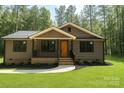 Charming home with brown siding, covered porch, black railings and trim, manicured lawn, and tasteful landscaping at 2330 Neill Rd, Lancaster, SC 29720