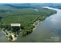 Aerial view of the property at 24756 Strand Dr, Albemarle, NC, nestled on the lake with lush trees at 24756 Strand Dr, Albemarle, NC 28001