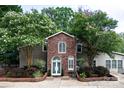 Charming front exterior showcasing a brick facade, arched windows, landscaped garden beds, and a welcoming entrance at 24756 Strand Dr, Albemarle, NC 28001