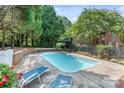 Inviting outdoor pool area with lounge chairs, surrounded by mature trees and a private, tranquil setting at 24756 Strand Dr, Albemarle, NC 28001