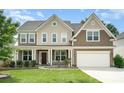 Charming two-story home with a well-maintained lawn, covered porch, and attached two-car garage at 2577 Shoal Park Rd, Concord, NC 28027