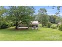 Expansive backyard with a covered patio, fire pit area, and mature trees, providing ample outdoor space at 3980 English Oak Dr, Lincolnton, NC 28092