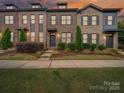 Townhome's facade showcases lovely brickwork, mature trees, and a beautifully kept lawn at 416 Linestowe Dr, Belmont, NC 28012