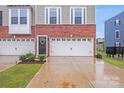 Close up of brick and gray townhome exterior and driveway with attached garage at 416 Moondance Dr # 121, Gastonia, NC 28054