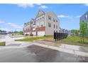 View of the exterior of gray townhomes with driveways and lawns on a sunny day at 416 Moondance Dr # 121, Gastonia, NC 28054