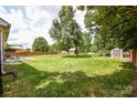 Expansive backyard featuring a well-maintained lawn, a storage shed, and mature trees at 4320 Atkinson Way, Monroe, NC 28110