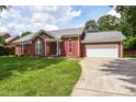 Beautiful brick home with red shutters, well-kept lawn, and a spacious two-car garage at 4320 Atkinson Way, Monroe, NC 28110