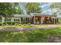 Classic brick home with a brick walkway, manicured bushes, black shutters, and a welcoming front porch at 441 Crestside Se Dr, Concord, NC 28025