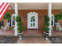 Charming front porch with brick flooring, classic white columns, hanging ferns, and rocking chairs at 441 Crestside Se Dr, Concord, NC 28025