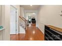 Bright hallway featuring wood floors, staircase, and entryways into the living spaces at 5111 Elementary View Dr, Charlotte, NC 28269