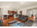 Open-concept living room and kitchen with wood floors, sofa, and stainless steel appliances at 5111 Elementary View Dr, Charlotte, NC 28269