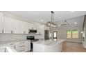 Bright kitchen with a marble island, stainless steel appliances, modern lighting, and lots of cabinets at 5526 Brookwood Ln, Hickory, NC 28602