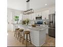 Bright kitchen featuring a marble island, stainless steel appliances, and modern light fixtures at 5526 Brookwood Ln, Hickory, NC 28602