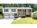 Charming brick and vinyl home with a well-manicured lawn and an attached two-car garage at 5909 Ryder Ave, Charlotte, NC 28226
