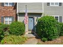 Close-up of a charming entryway with an American flag, shrubs, and brick accents at 6044 Heath Valley Rd, Charlotte, NC 28210