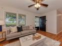 Cozy living room with hardwood floors, modern sofa, and ample natural light from the large front window at 713 Springfield Nw Dr, Concord, NC 28027