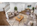 Bright staged living room with hardwood floors, neutral furniture, and a view into the dining room at 7134 Rollingridge Dr, Charlotte, NC 28211