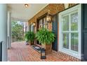 Close-up of a brick-paved front porch with plants and black shutters, radiating classic Southern charm at 748 Land Fall Dr, Rock Hill, SC 29732
