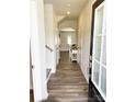 Bright foyer with hardwood flooring, white trim, arched doorway, and convenient coat closet, leading into living area at 8060 Scarlet Maple Ln, Tega Cay, SC 29708