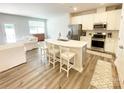 Open-concept kitchen and living area with modern appliances, light countertops, and a breakfast bar with seating at 8060 Scarlet Maple Ln, Tega Cay, SC 29708