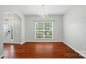 Bright dining room featuring hardwood floors, a chandelier, and a large window overlooking the yard at 8115 Kelburn Ln, Charlotte, NC 28273