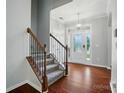 Inviting entryway with hardwood floors, decorative chandelier, and a staircase with carpeted steps at 8115 Kelburn Ln, Charlotte, NC 28273