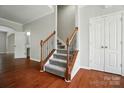 Elegant foyer showcasing hardwood floors, a carpeted staircase with iron spindles, and neutral paint at 8115 Kelburn Ln, Charlotte, NC 28273