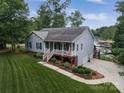 Charming home featuring a welcoming porch, manicured lawn, and convenient driveway leading to the garage at 8593 Bailey Dr, Terrell, NC 28682