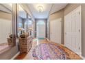 Bright foyer with hardwood floors and natural light features storage furniture and large mirrors at 901 Clearbrook Rd, Matthews, NC 28105
