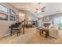 Cozy living room with a fireplace, piano, and ceiling fan, perfect for relaxation and entertainment at 901 Clearbrook Rd, Matthews, NC 28105