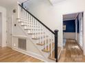 A view of a staircase with hardwood steps and a white railing leading to the upper level at 9622 Penshurst Trce, Charlotte, NC 28210