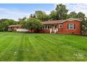 Charming brick home with a well-manicured lawn and a cozy porch, perfect for relaxing outdoors at 10637 Highway 52 Hwy, Rockwell, NC 28138