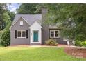 Charming gray brick home with a quaint teal front door and well-manicured lawn at 1106 S South St, Gastonia, NC 28052