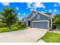 Lovely one story home with a well-manicured lawn, mature tree and a two car garage with a blue colored exterior at 138 Chase Water Dr, Mooresville, NC 28117
