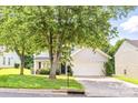 Inviting front yard featuring a large tree, well-kept lawn, and a charming two-story home at 1515 Kingdom Way, Fort Mill, SC 29707