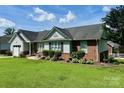 Well-kept one-story home with brick and siding, lush landscaping, and a green lawn at 1700 Pickwick Ave, Kannapolis, NC 28083